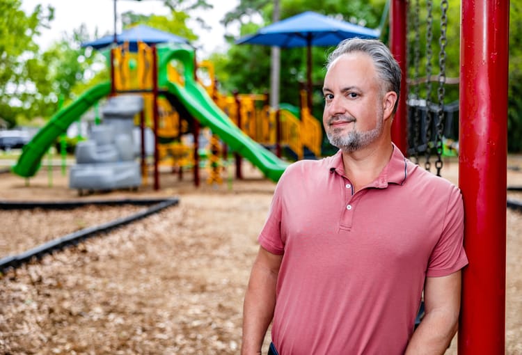 Phil Nickinson standing alongside a swing set at a park in Pensacola